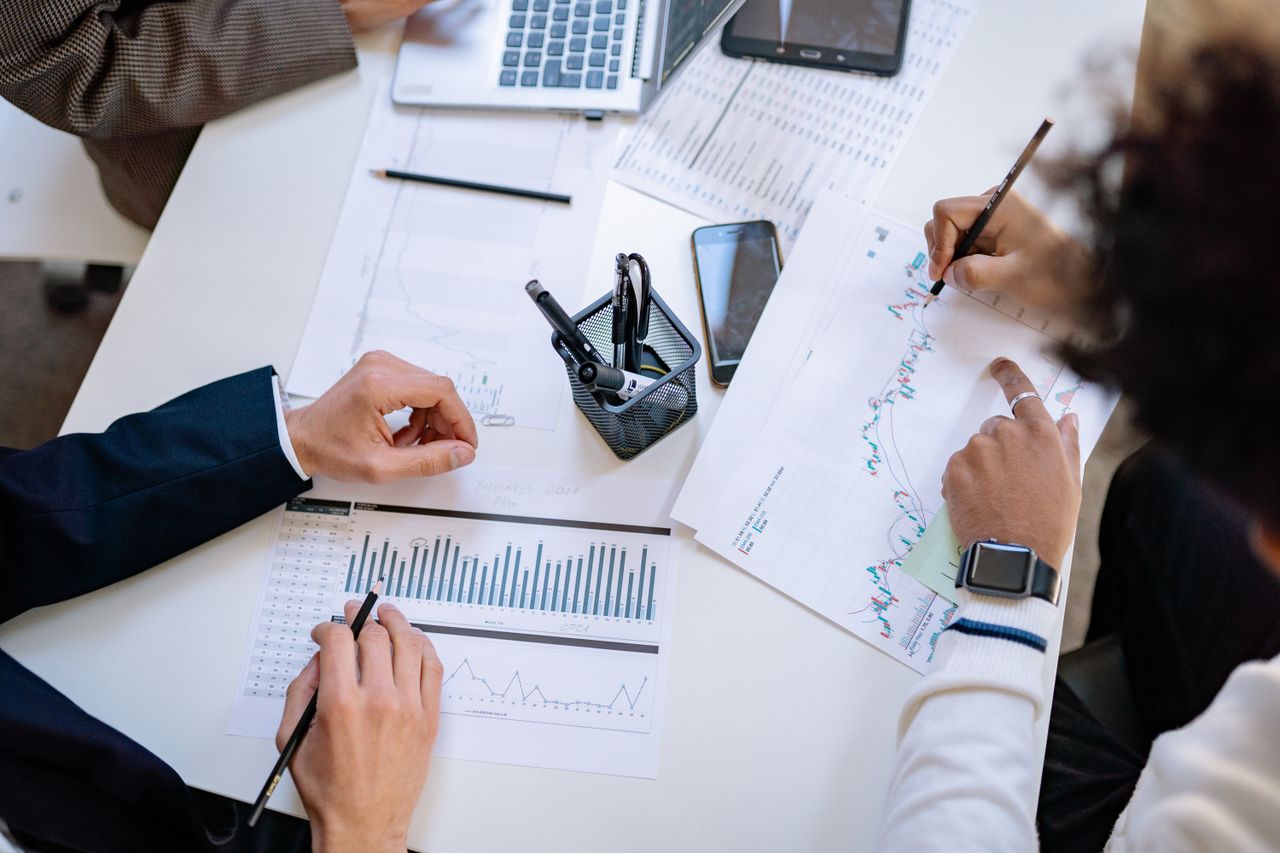 why-choose-us Business team analyzing financial charts and graphs during a collaborative meeting.